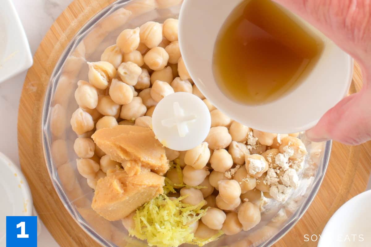 Chickpeas and other ingredients in a food processor bowl.