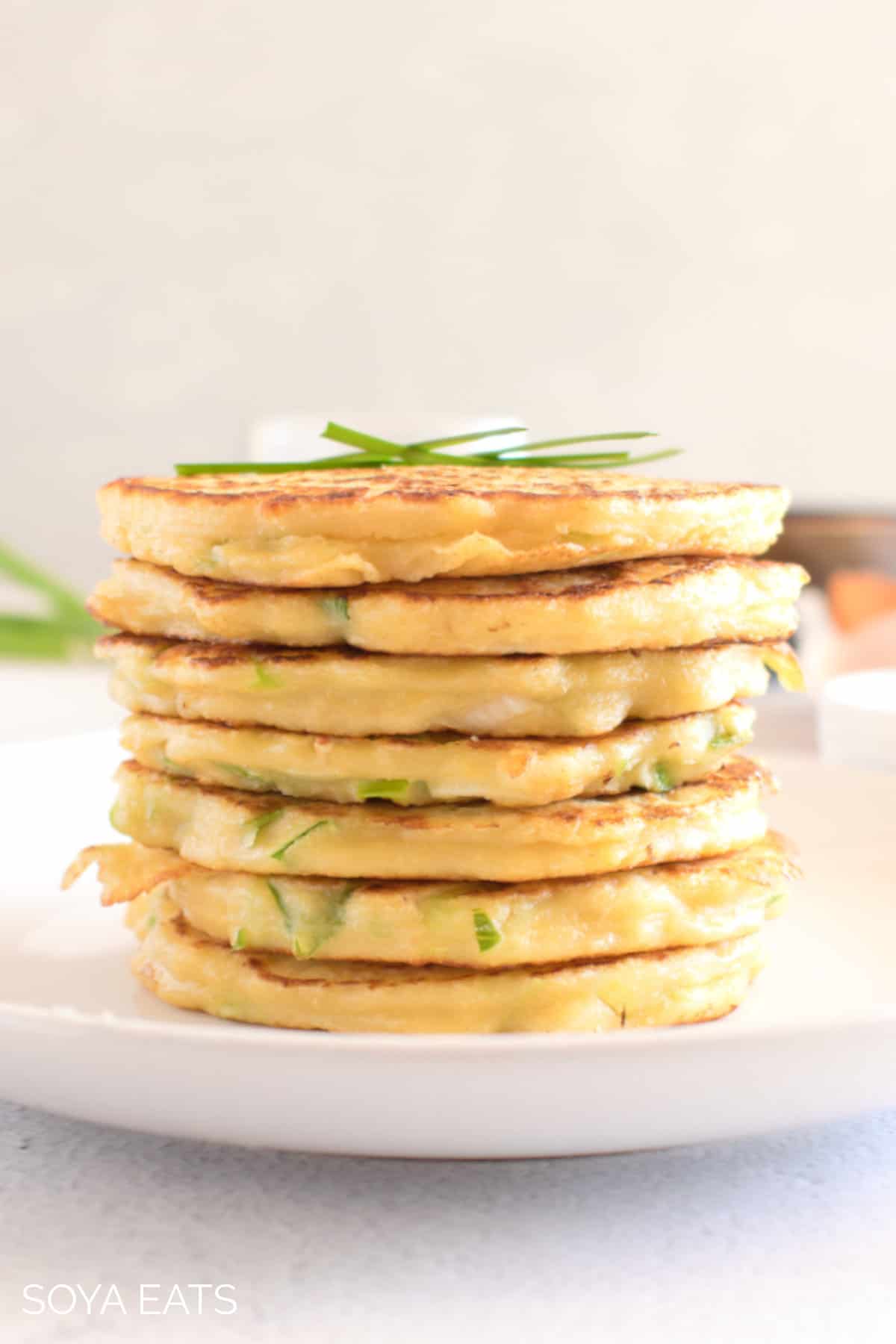A stack of pancakes with spring onions.