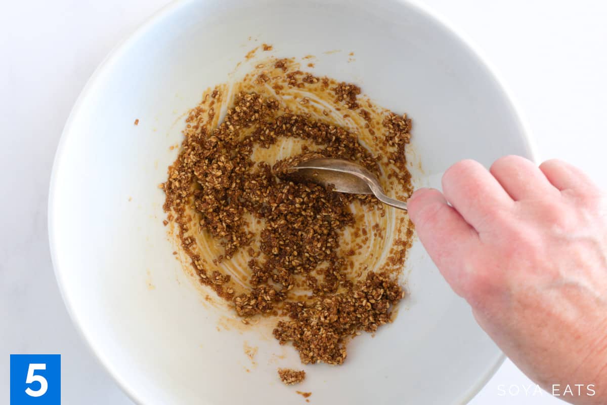 Mixing a sesame and soy sauce dressing in a large bowl.