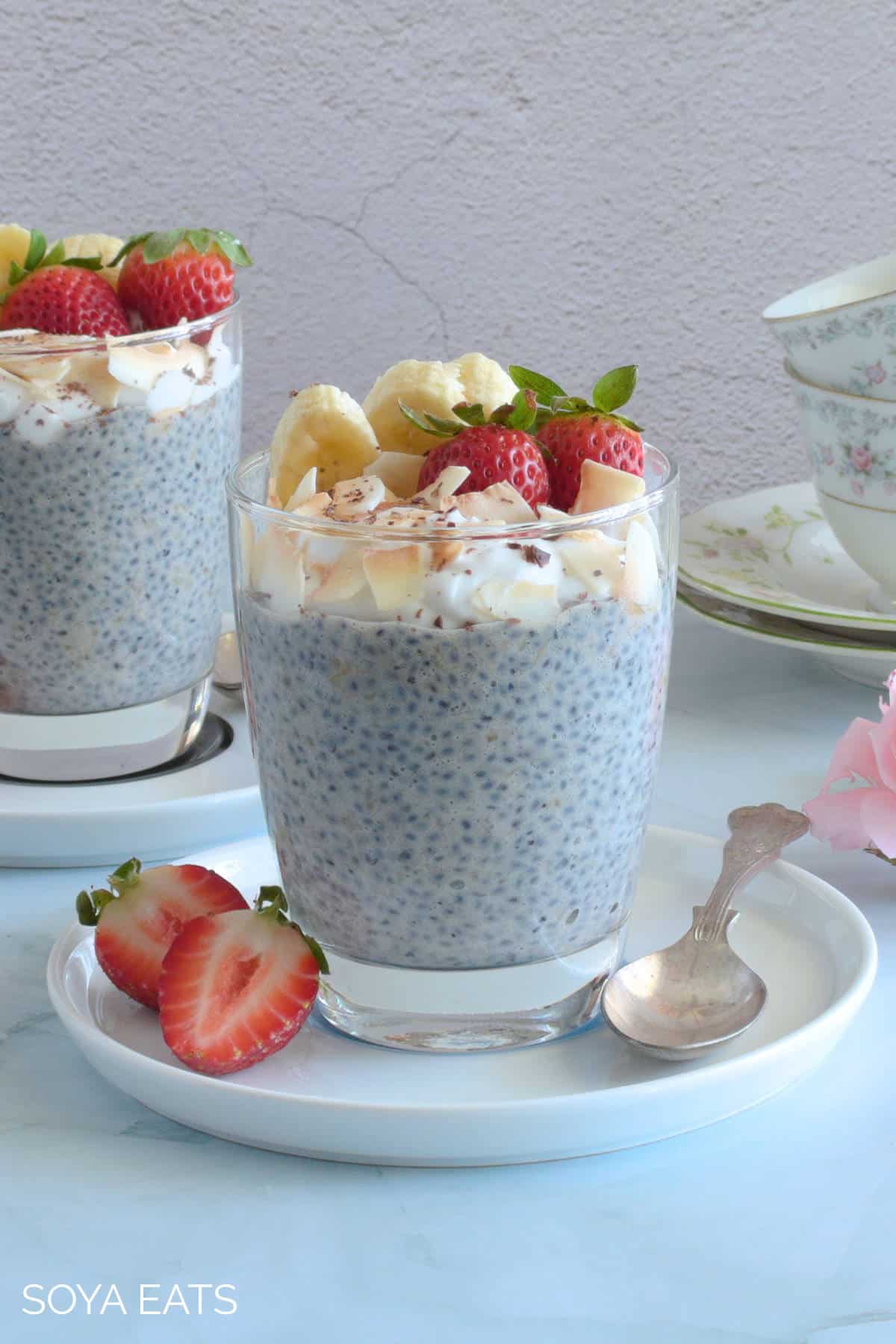 Image of two chia banana puddings on white plates and spoons.