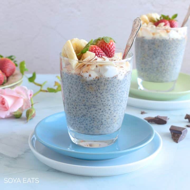 Banana chia pudding in a glass on a blue plate.