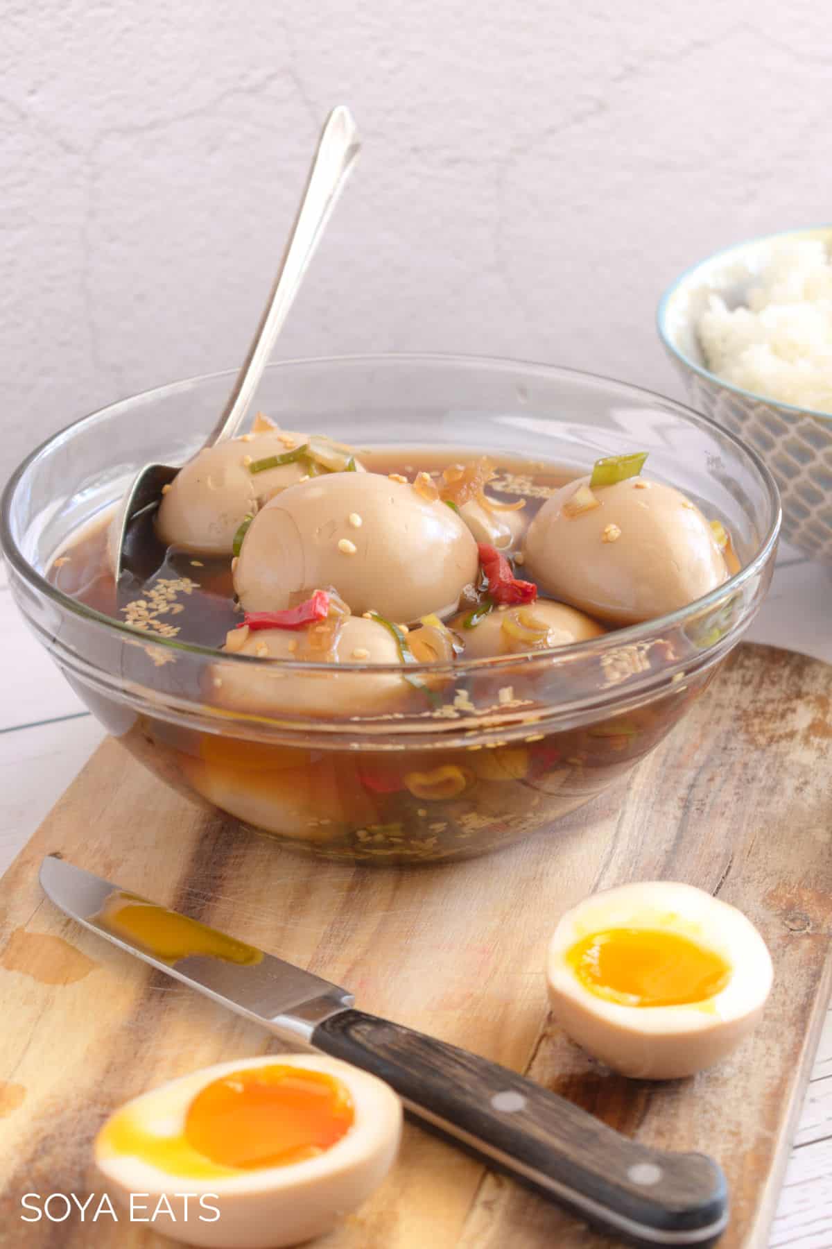 A glass bowl with Korean marinated eggs and marinade.