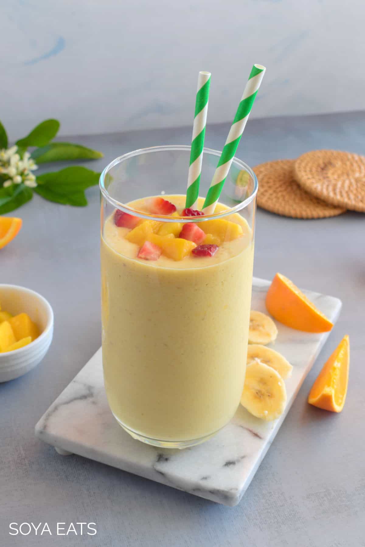 A mango smoothie with fruit on top.