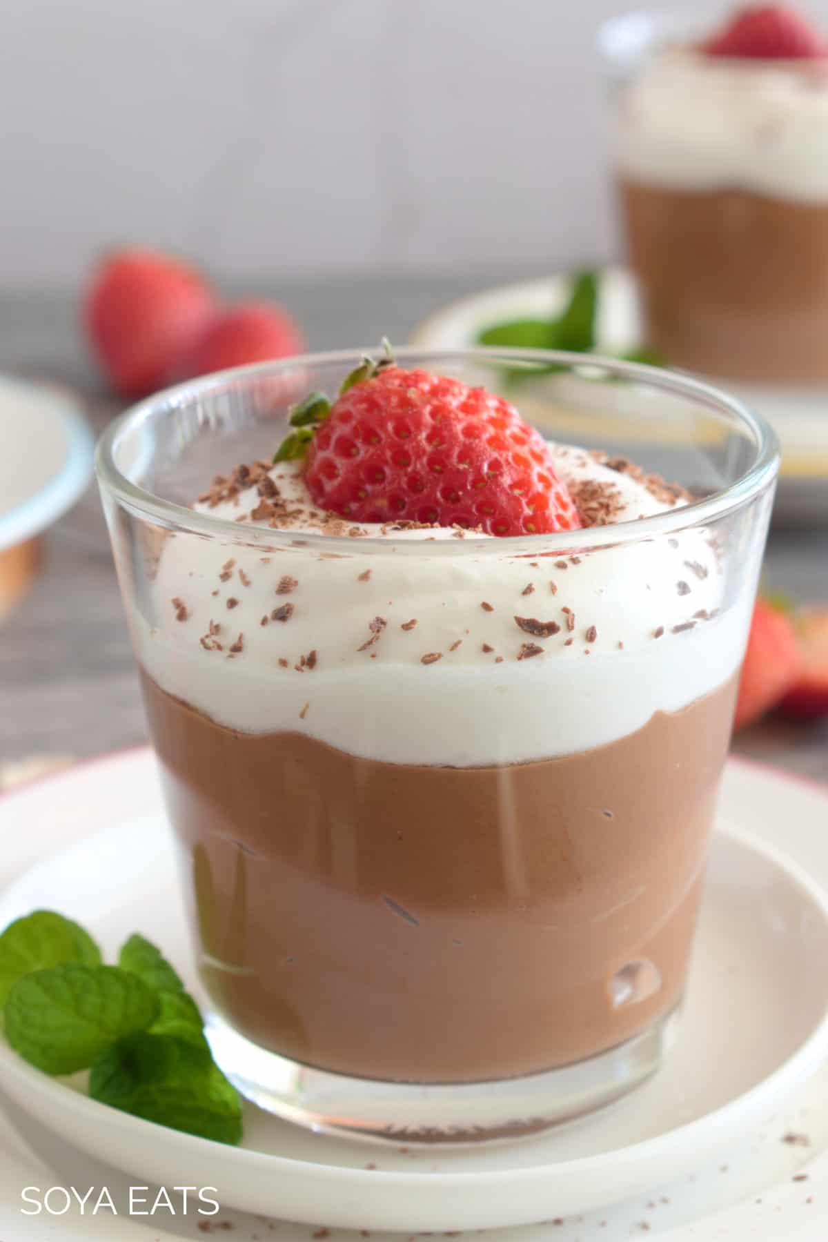 Tofu chocolate mousse with dairy free cream and a strawberry.