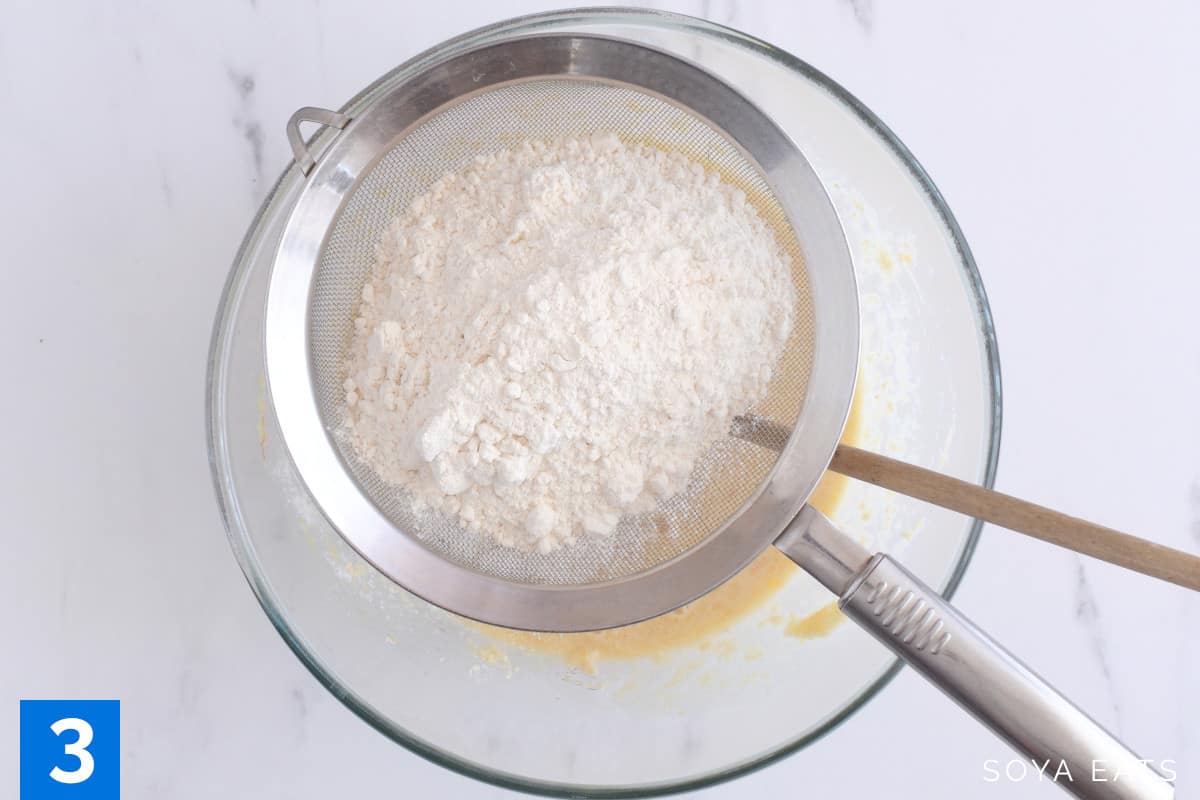 Flour in a sieve set over a mixing bowl.